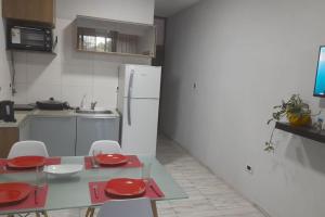 eine Küche mit einem Tisch und einem weißen Kühlschrank in der Unterkunft Somos Nomades Departamento (entero) 1 Zona Parque Central in La Cieneguita