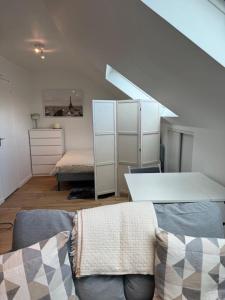 een woonkamer met een bank en een bed bij Studio Saint Cyr in Saint-Cyr-lʼÉcole