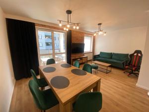 a living room with a table and green chairs at ApartamentAugust in Zielona Góra