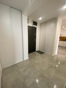 an empty room with sliding glass doors and a hallway at ApartamentAugust in Zielona Góra +5 photos