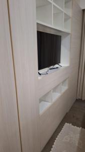 um armário branco com uma televisão nele em FLAT HOTEL EM ALPHAVILLe ÓTIMA LOCALIZAÇÃO em Barueri