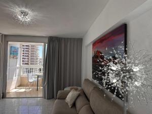 una sala de estar con sofá y una gran pintura en la pared en Playa de San Juan JULIA, en Alicante