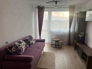 a living room with a purple couch and a window at Apartament Perła in Gdańsk