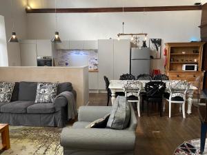 a living room with a couch and a table at Creative Norfolk Chapel with Piano and Sauna Sleeps 10 in Briston