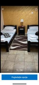 um quarto com duas camas e uma mesa com um candeeiro em Dody apartmani em Leskovac