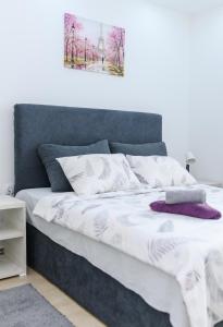 a bed with white sheets and purple pillows at Sara 4 in Soko Banja