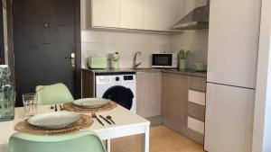 a kitchen with a table and chairs and a dishwasher at Javea's Port apartment in Jávea