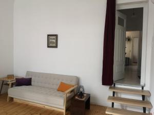 ein Wohnzimmer mit einem weißen Sofa und einem Spiegel in der Unterkunft Exklusive 3-Zimmer-Wohnung, 2 Ebenen, Messe, Zentrum, 67 m2 in Bremen