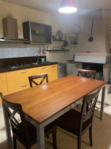 een keuken met een houten tafel en stoelen bij Villa Silvia in Fontana Liri Inferiore