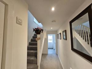 a hallway with a staircase with a vase of flowers at Modern 3 Bedroom Town House in Ipswich
