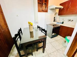 una cucina con un tavolo su cui è appoggiato un vaso di fiori di Studio Eleni a Mykonos Città