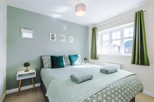 um quarto com uma cama com duas almofadas em Modern Semi detached in a quiet location, Driveway parking em Ewloe
