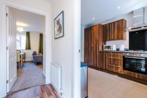 uma cozinha com armários de madeira e uma sala de estar em Modern Semi detached in a quiet location, Driveway parking em Ewloe