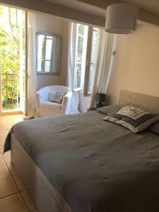 um quarto com uma cama, uma cadeira e janelas em Magnifique Villa avec Piscine em Aix-en-Provence