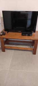 TV de pantalla plana sobre una mesa de madera en Φωλιά, en Olympos