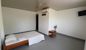 1 dormitorio con cama y mesa pequeña en Casa Turística Macarena Tierra salvaje, en La Macarena