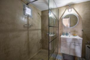 a bathroom with a shower and a sink and a mirror at Cosy Cottage in Stalida +14 photos