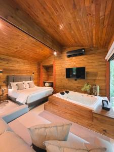 um quarto com 2 camas e uma banheira em Cabana equipada em meio à natureza em Pomerode em Pomerode