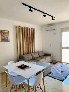 uma sala de estar com um sofá, uma mesa e cadeiras em Eden Home em Durrës
