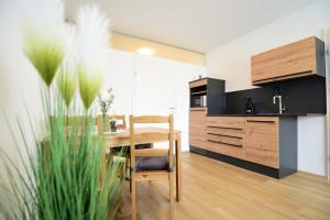 a kitchen with a wooden table and a dining room at PM-APART Premstätten in Premstätten