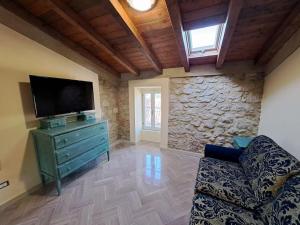 a living room with a tv and a stone wall at Silvia House in Prossedi