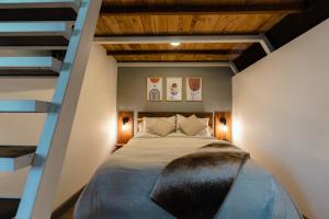 Schlafzimmer mit einem Bett mit Holzdecke in der Unterkunft EyB Chalets in Heredia