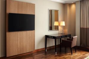 a hotel room with a desk and a television on a wall at Sheraton Bratislava Hotel in Bratislava
