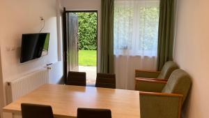 a conference room with a table and chairs and a television at Apartament Kopytko in Bielsko-Biała