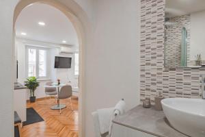 a white bathroom with a sink and a table at Studio apartment in the heart of magic Piran in Piran