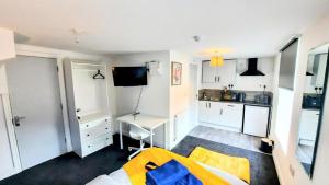 a room with a bed and a kitchen with white cabinets at Premier Nottingham Studios - Burford Road in Nottingham