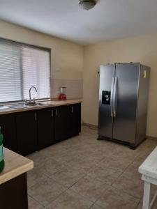 eine Küche mit einem Kühlschrank aus Edelstahl und einer Spüle in der Unterkunft Amplia Casa en Sector Viñedos (factura) in Torreón