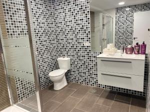 La salle de bains est pourvue de toilettes, d'un lavabo et d'une douche. dans l'établissement Suite bahía, à Séville