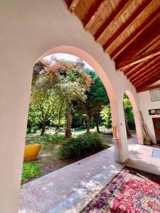 ein Torbogen, der in einen Garten mit Bäumen im Hintergrund führt in der Unterkunft La casa nel parco in Mogliano Veneto