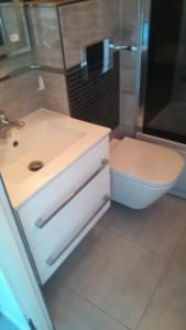 Mieszkanie w Tucholi في توكولا: حمام مع حوض أبيض ومرحاض