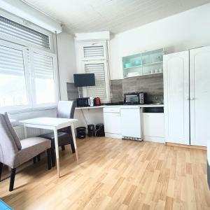 a kitchen with white cabinets and a table and chairs at FMI9Accomation Raunheim in Raunheim