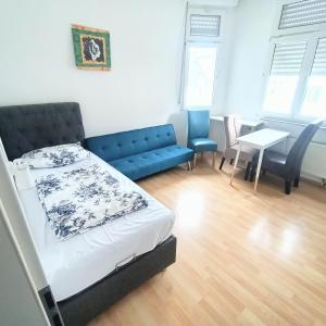 a bedroom with a bed and a couch and a table at FMI9Accomation Raunheim in Raunheim