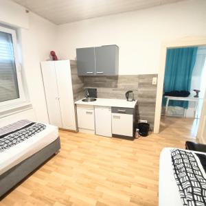 een kamer met 2 bedden en een keuken met een bureau bij FMI9Accomation Raunheim in Raunheim