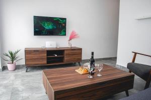 uma sala de estar com uma mesa com copos de vinho e uma televisão em Birzebbuga -Two Bed Penthouse em Birzebbuga