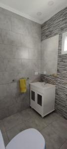 ein Badezimmer mit einem weißen Waschbecken und einem Spiegel in der Unterkunft El Aromo in Junín