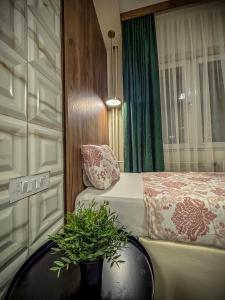 a bedroom with a bed and a table with plants at Calla Bella Rooms & Snack Bar in Skopje