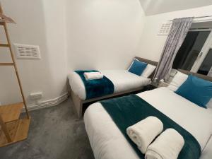 a room with two beds with blue and white at Tooting Lodge London - Cosy 2 bedroom house with garden in London
