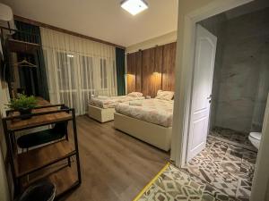 a room with two beds and a door to a bedroom at Calla Bella Rooms & Snack Bar in Skopje
