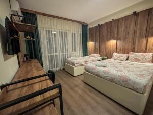 a bedroom with two beds and a tv in it at Calla Bella Rooms & Snack Bar in Skopje