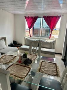 uma sala de estar com sofás e uma mesa de vidro em Departamento amoblado en Kennedy central em Bogotá