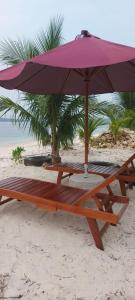 stół piknikowy i parasol na plaży w obiekcie Jelita Beach Mentawai w mieście Tua Pejat