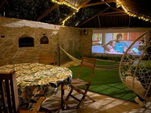 a patio with a table and chairs and a large screen at Relajante Casa Atalaya in Cardiel de los Montes