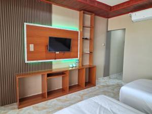 a hotel room with a tv and a bed at Jelita Beach Mentawai in Tua Pejat