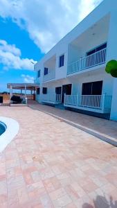 a large white building with a patio in front of it at Yobcar66 in San Fernando de Monte Cristi