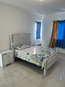 a bedroom with a bed and a night stand at Yobcar66 in San Fernando de Monte Cristi