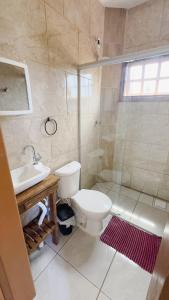 ein Bad mit einem WC, einem Waschbecken und einer Dusche in der Unterkunft Bella Praia apartamento Girassol in Passo de Torres